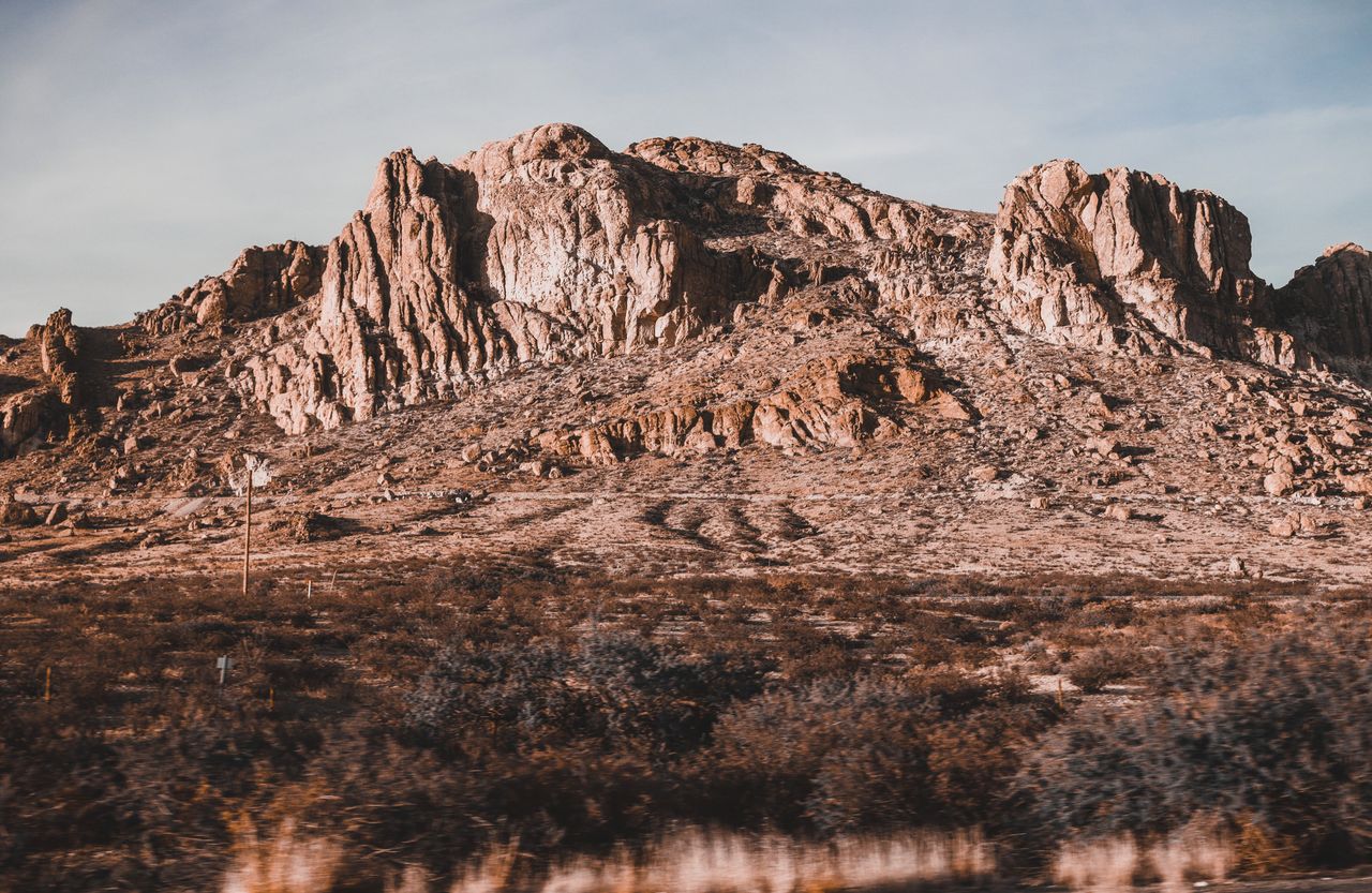 Captivating rocky desert landscape with towering cliffs under a clear sky in daylight.